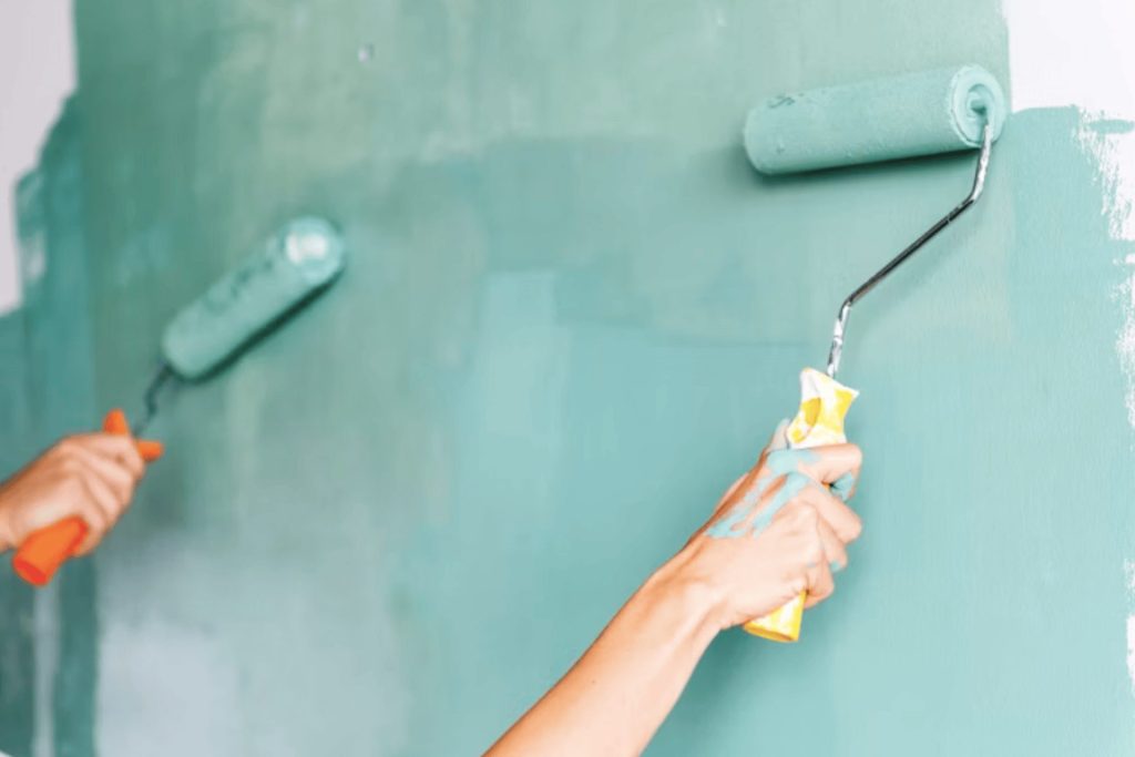 Wall decorators in Swansea painting a wall green with rollers