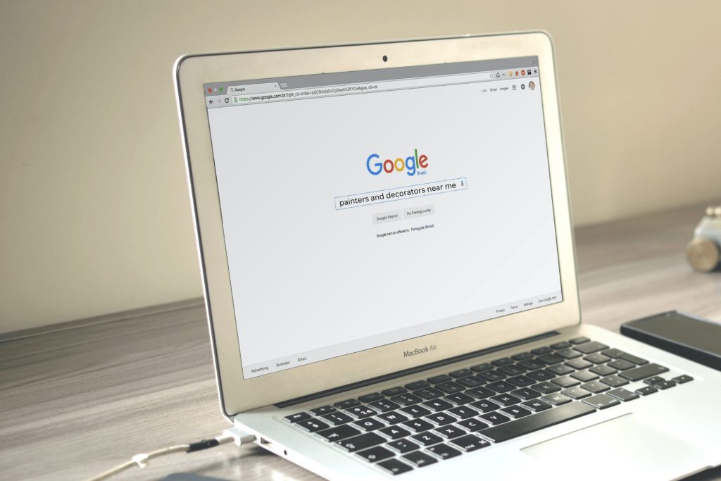 Someone searching on Google on a MacBook Air for painters and decorators near me